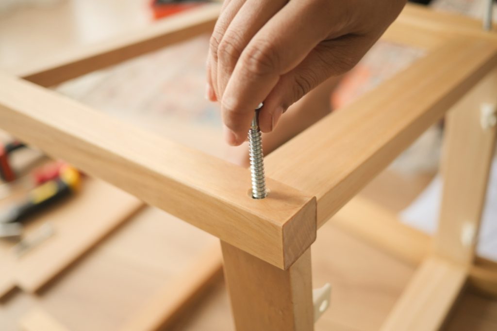 Une personne qui travaille pour recouvrir une table en verre avec du bois