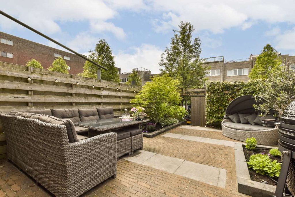 Une terrasse en contrebas d'un jardin avec des meubles