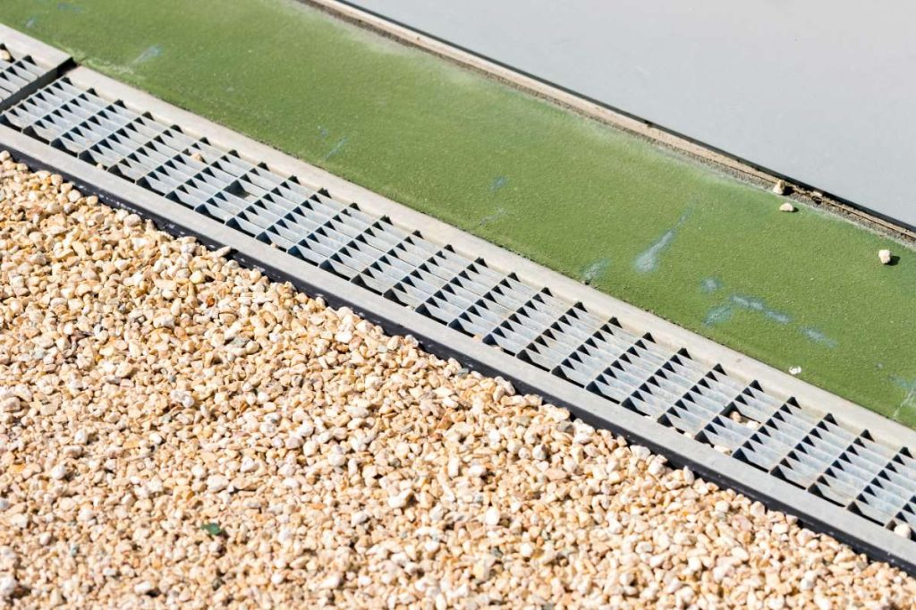 Un caniveau à grille devant une maison