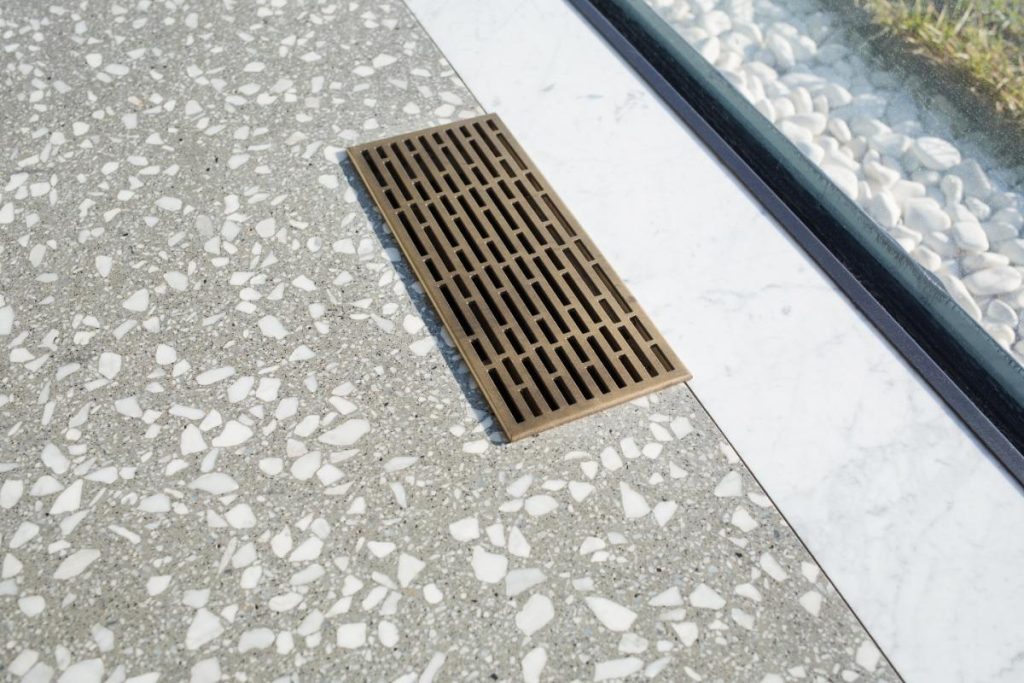Un caniveau à grille installé dans la cour