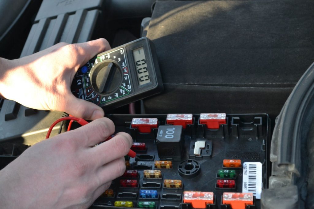 Une personne qui fait tester la prise de remorque 7 broches avec un multimètre