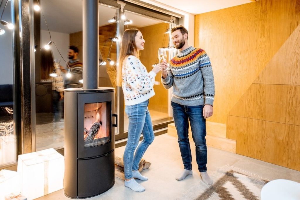 Couple heureux devant leur cheminée entretenue