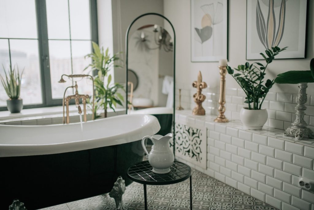 Une élégante baignoire avec un robinet une plante d'intérieur dans la salle de bain