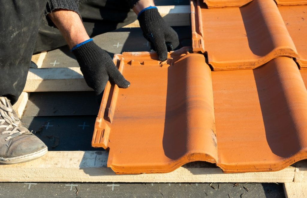 Un couvreur installant des tuiles sur le toit