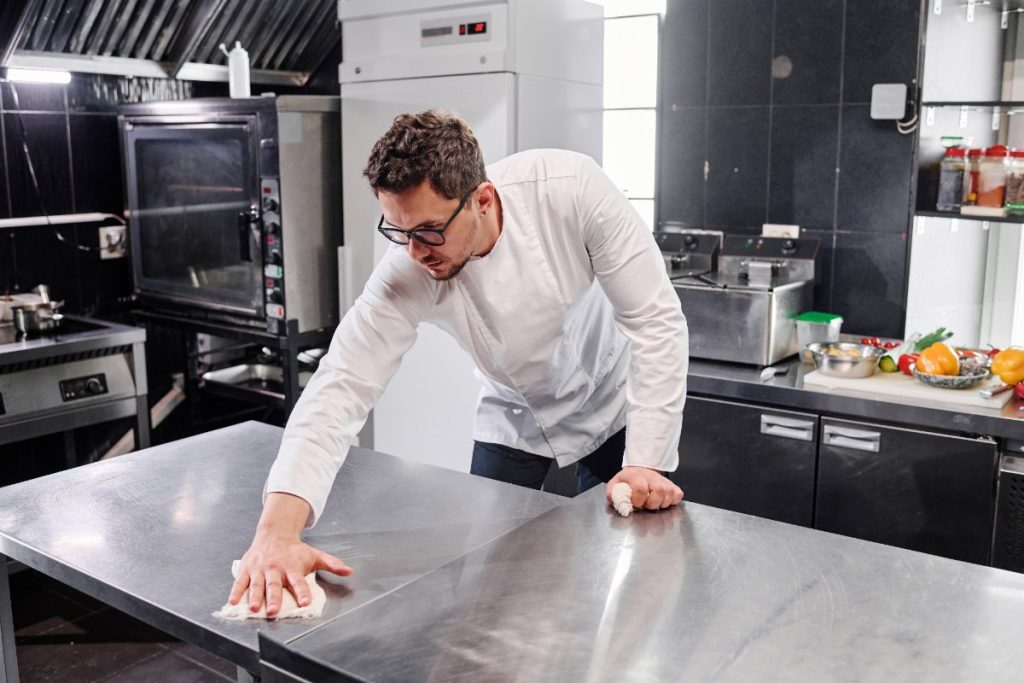 Un homme qui nettoie une surface en inox