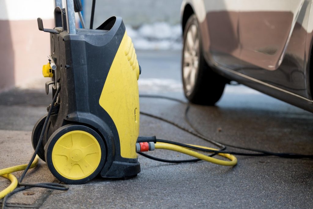 Un nettoyeur kärcher placé près d'une voiture
