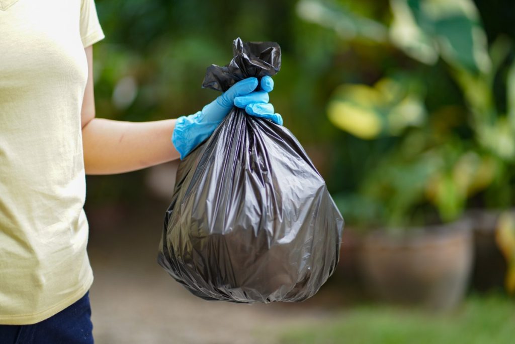 Une personne tenant un sac poubelle