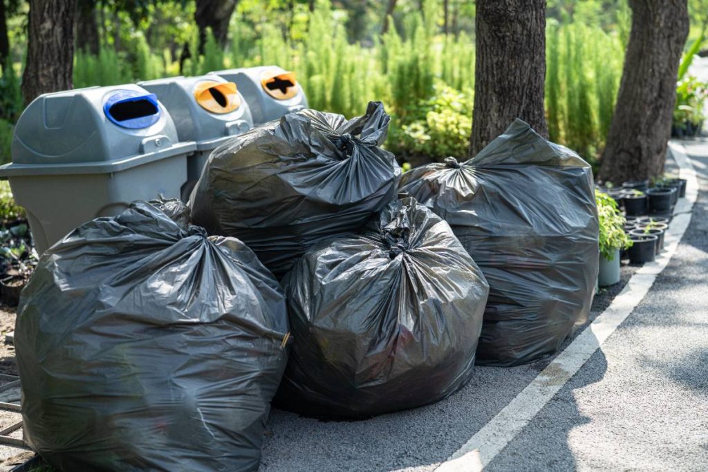 Des sacs poubelles en plastiques dans le jardin