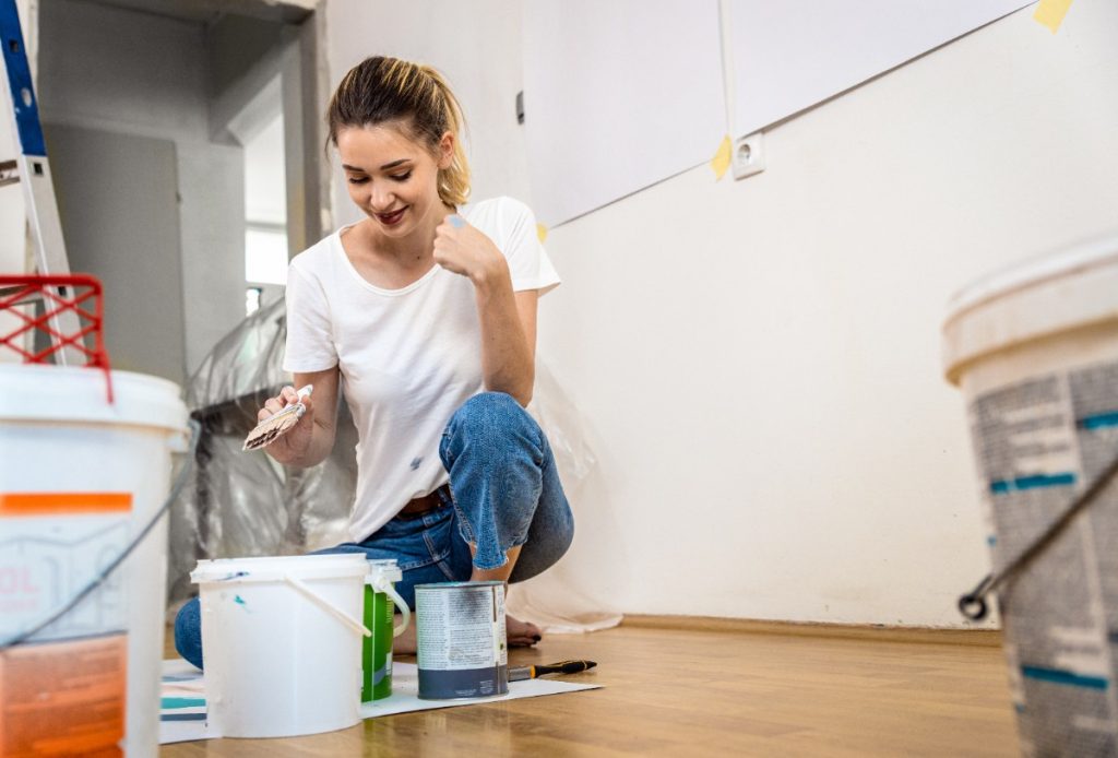 Une femme préparant la peinture dans un appartement