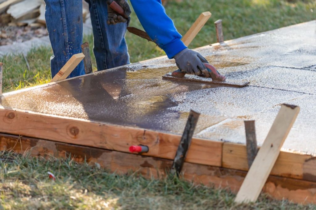 Un homme faisant un lissage sur la surface en béton