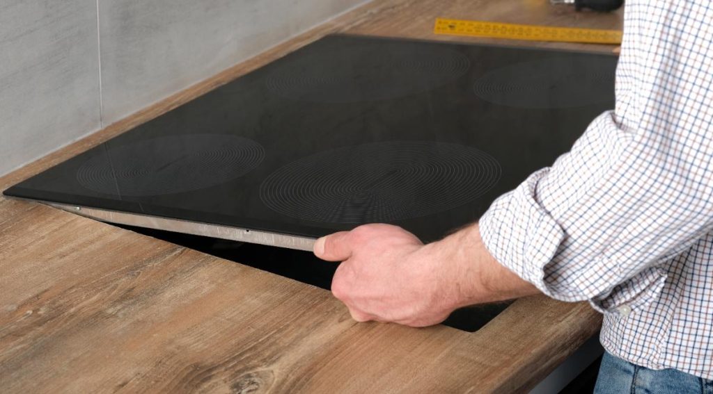 Mains enlèvant une plaque à induction