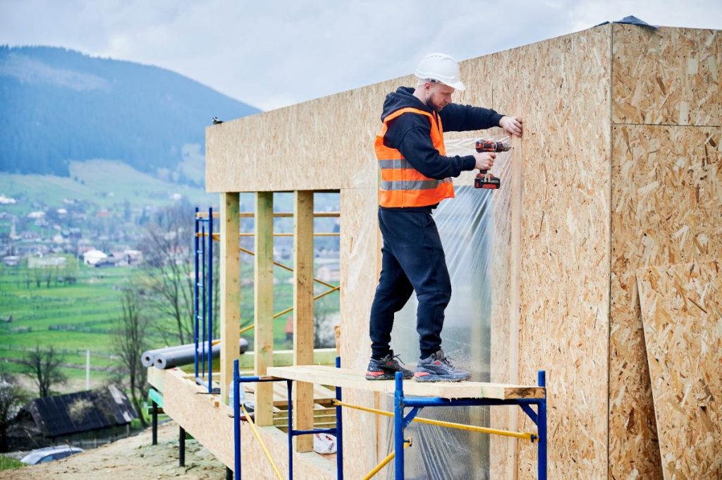 Un ouvrier installant une plaque OSB