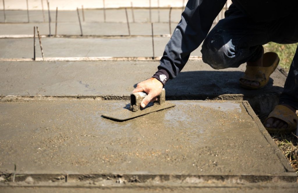 Un ouvrier lissant la dalle de ciment