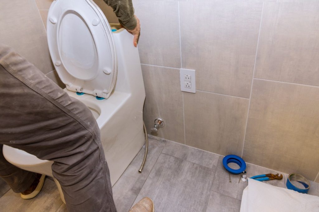 Un plombier installant de nouveaux toilettes
