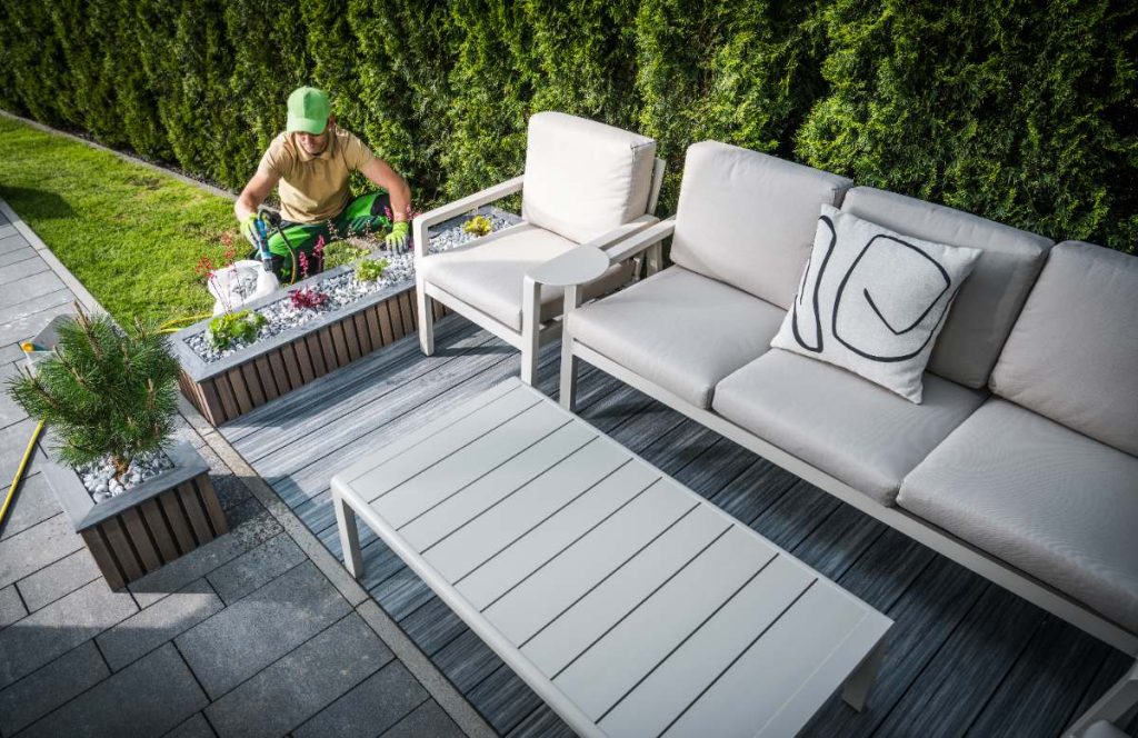 Un homme aménageant la terrasse avec un petit jardin
