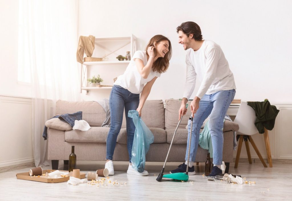 Un jeune couple nettoyant ensemble une maison